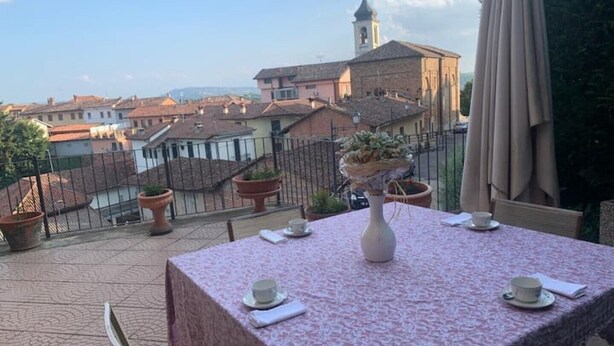 A table set for two with a view of a town and a church in the background.