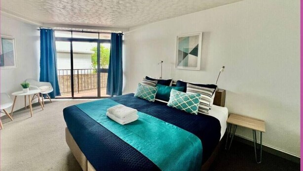 Un dormitorio con cama, escritorio y silla.