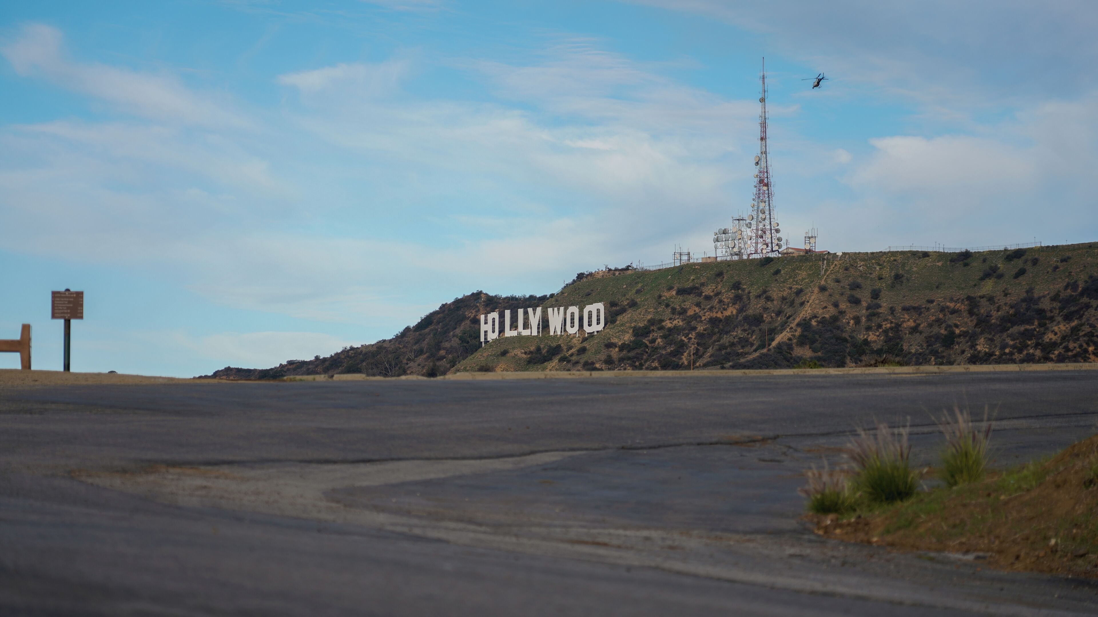 A road leading to a hill with the Hollywood sign.