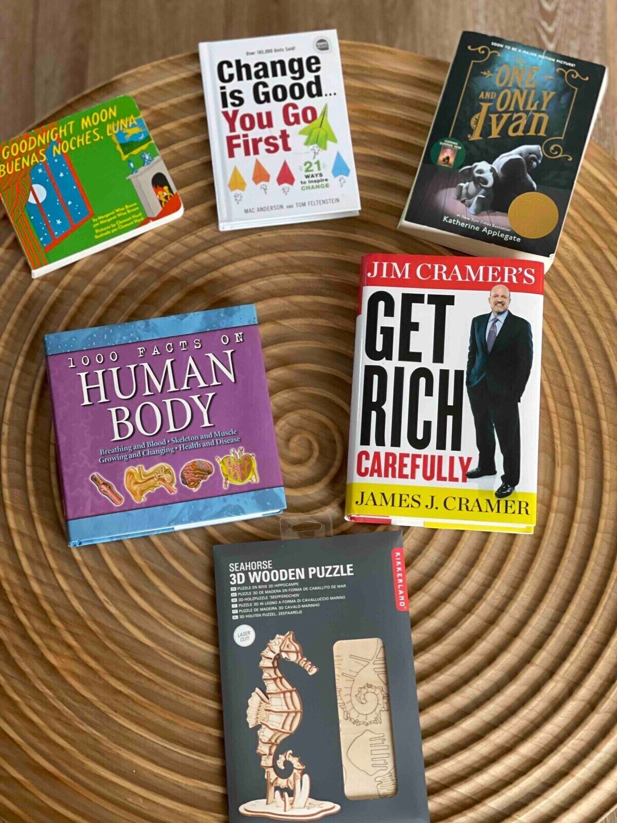 A collection of books and a 3D wooden puzzle on a wooden surface.