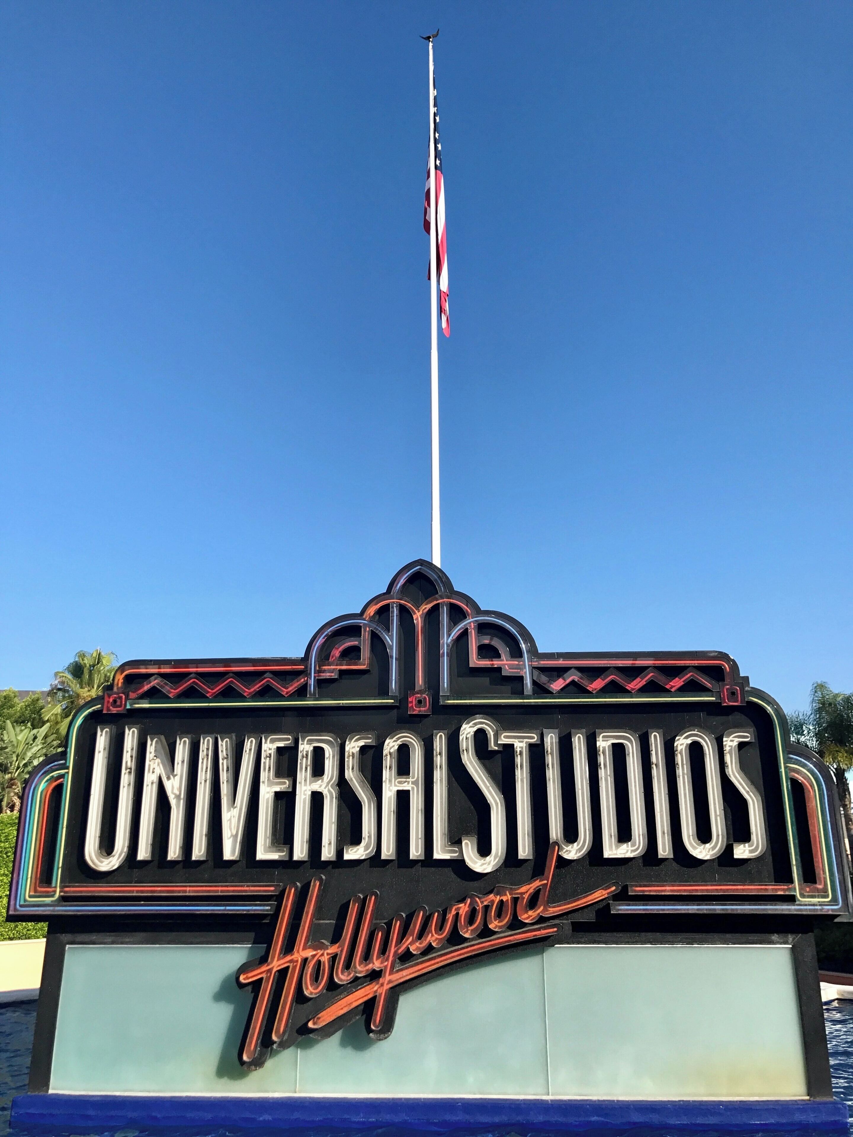A sign for Universal Studios Hollywood with a clear blue sky in the background.