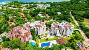 Ein Küstenresort mit mehreren Gebäuden, einem Schwimmbad und Blick auf das Meer.