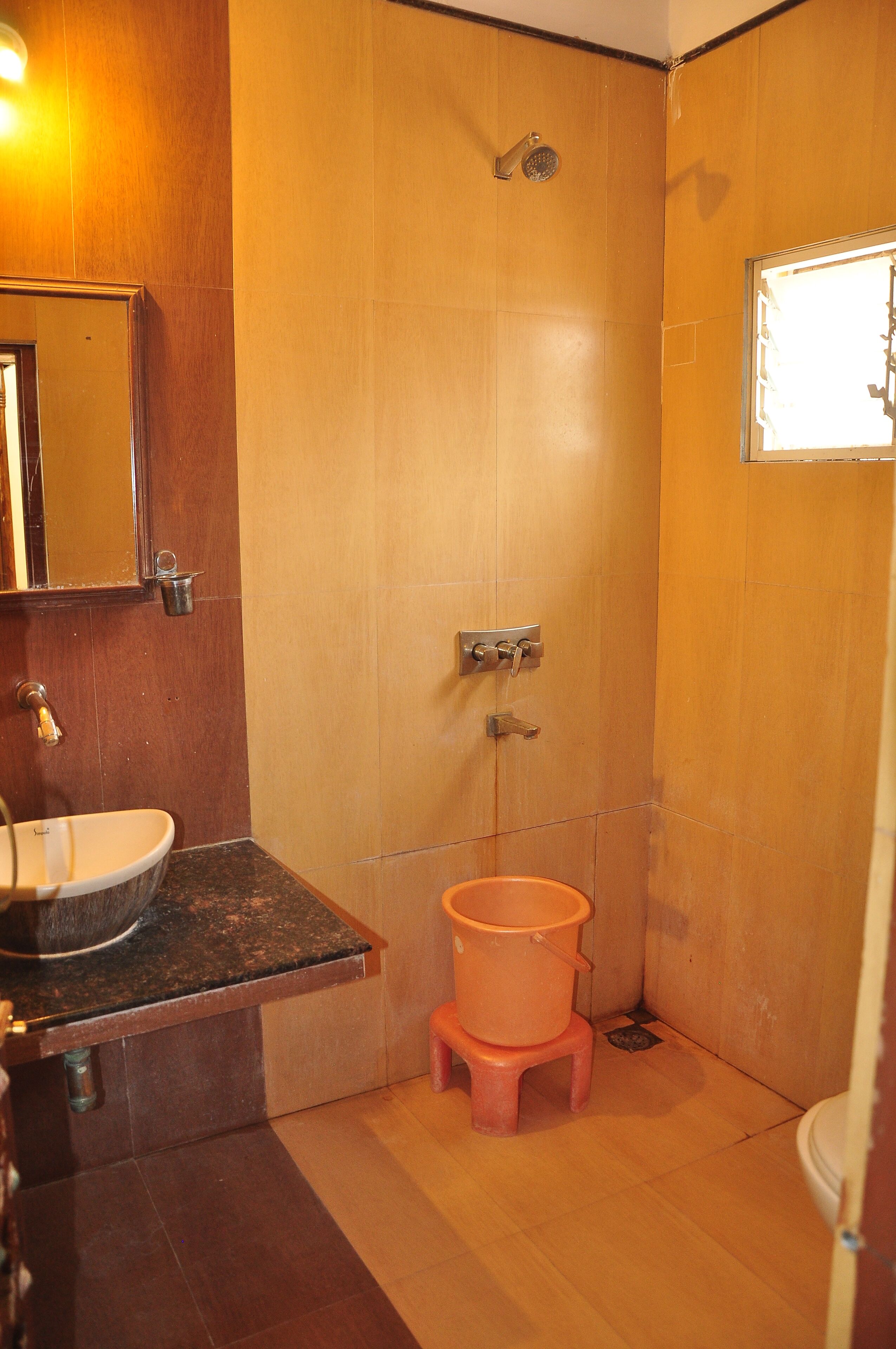 A bathroom with a sink, mirror, shower, and toilet.