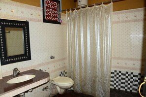 A bathroom with a sink, toilet, and a shower curtain. - NAKHRALI DHANI VILLAGE RESOTR LLP (Indore)