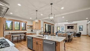 A spacious kitchen with granite countertops, wooden cabinets, and a central island. - Luxury Sunriver Escape with Access to Exclusive Golf (Sunriver)