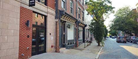 A brick building with a sign for 'Suite 222' and a fire hydrant on the sidewalk.