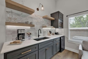 A modern kitchen with a white countertop, grey cabinets, and a built-in oven.