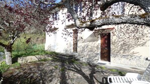 Un bâtiment en pierre avec une porte en bois et des marches menant à l’entrée.