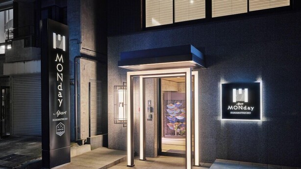 A hotel entrance with a modern design, a glass door, and a sign indicating it is Monday. - MONday Apart Premium Hamamatsucho (Tokyo)