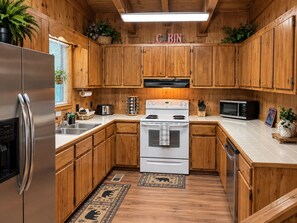 Une cuisine de style rustique, avec des meubles en bois, un réfrigérateur en acier inoxydable, une cuisinière et un four à micro-ondes.