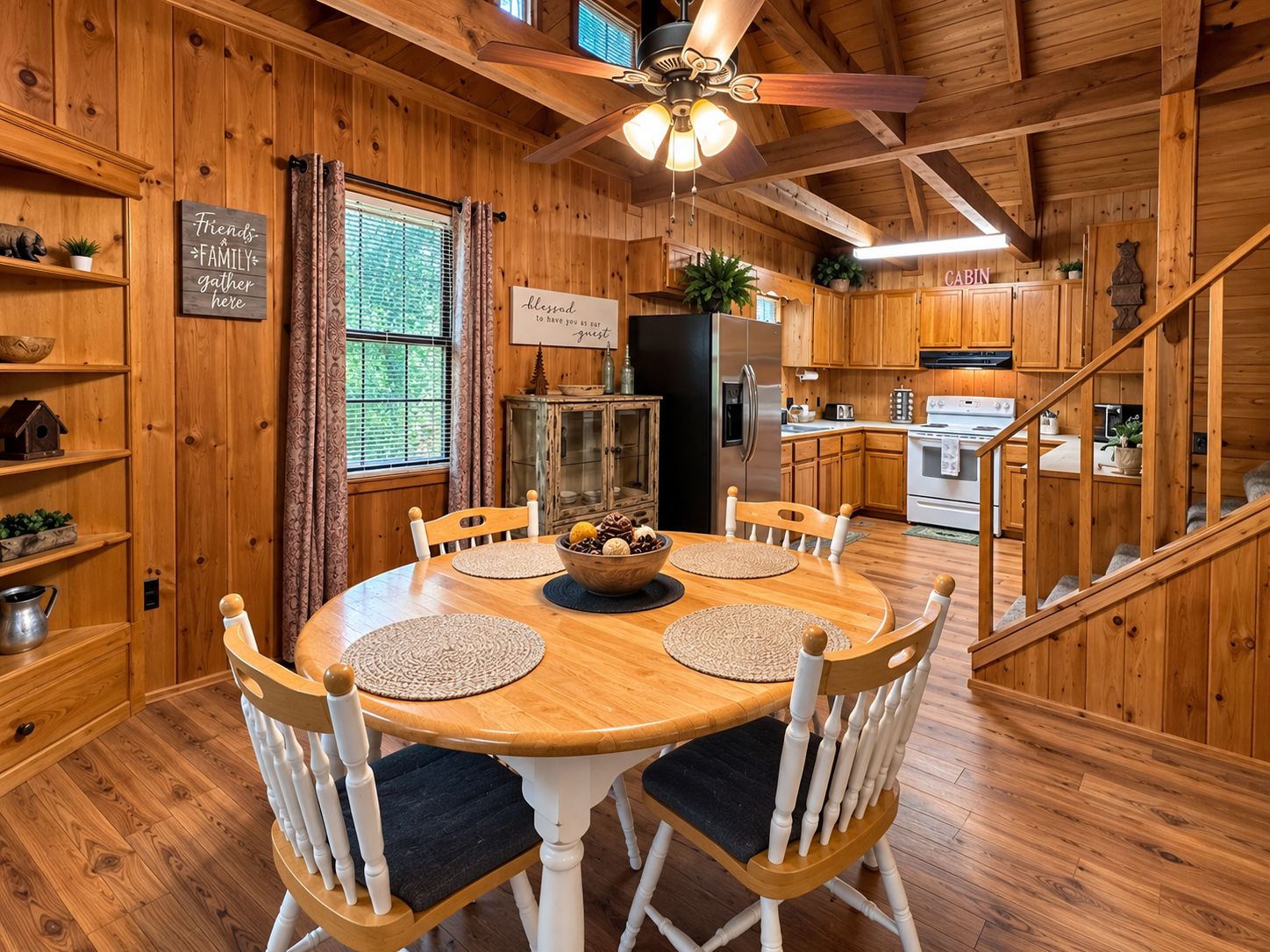 L’intérieur d’un chalet en bois comprend une table à manger, des chaises, un coin cuisine et un escalier.