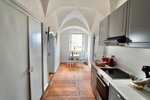 Enjoy meals in the spacious kitchen with a central island, sink, and stove, adjacent to a dining area with a table and chairs.
