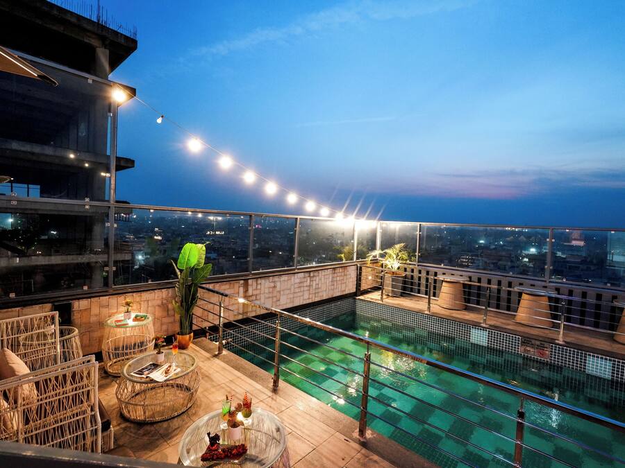 Een buitenzwembad, parasols bij het zwembad en ligstoelen