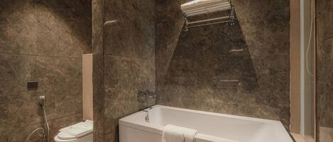 A modern bathroom with a freestanding bathtub, a toilet, and a shower area.
