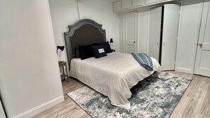 A bedroom with a bed, a nightstand, a dresser, and a walk-in closet. - Super Spacious 3 Bedroom House, w/2 Living Rooms and Close to Everything  (Shreveport)
