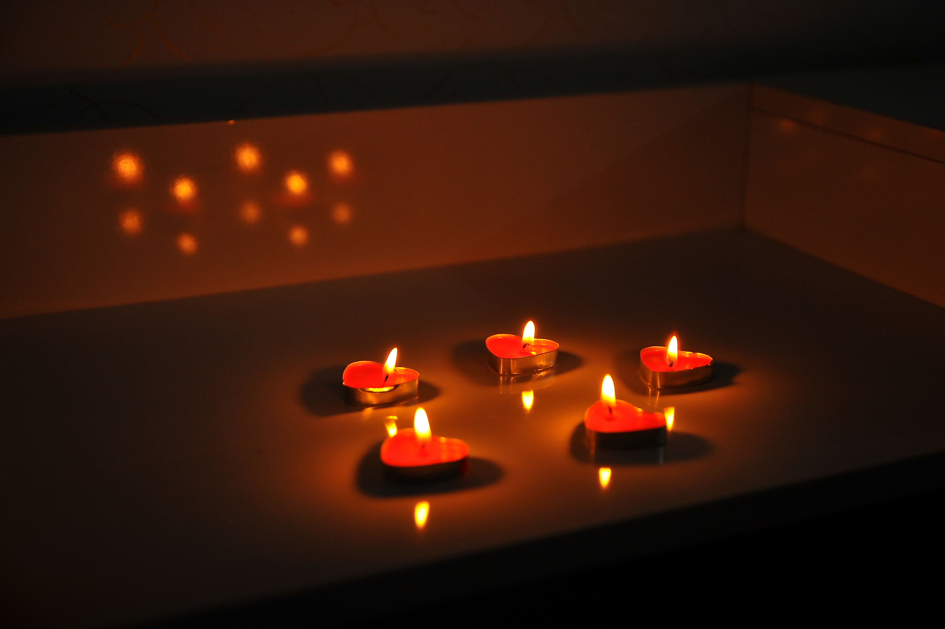 A row of lit candles on a flat surface.