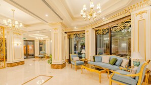 A luxurious lobby with ornate gold detailing, a blue sofa set, and a chandelier. - Braira Al Jubail (Al Jubail)