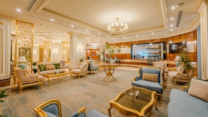 A spacious lobby with elegant seating, a reception desk, and a modern kitchen area. - Braira Al Jubail (Al Jubail)