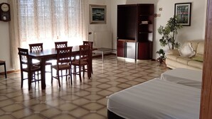 A room with a bed, a dining table with chairs, a chandelier, a radiator, and a bookshelf. - Cozy, warm and in a strategic neighborhood (Nardò)