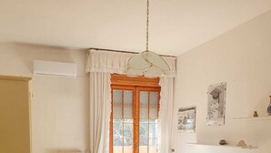 A bedroom with a bed, a chair, a wardrobe, a radiator, and a window with curtains. - Cozy, warm and in a strategic neighborhood (Nardò)