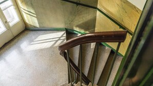 A staircase with a handrail and metal balusters, leading to a landing. - Spacious apt on Tranquil Courtyard (Helsinki)