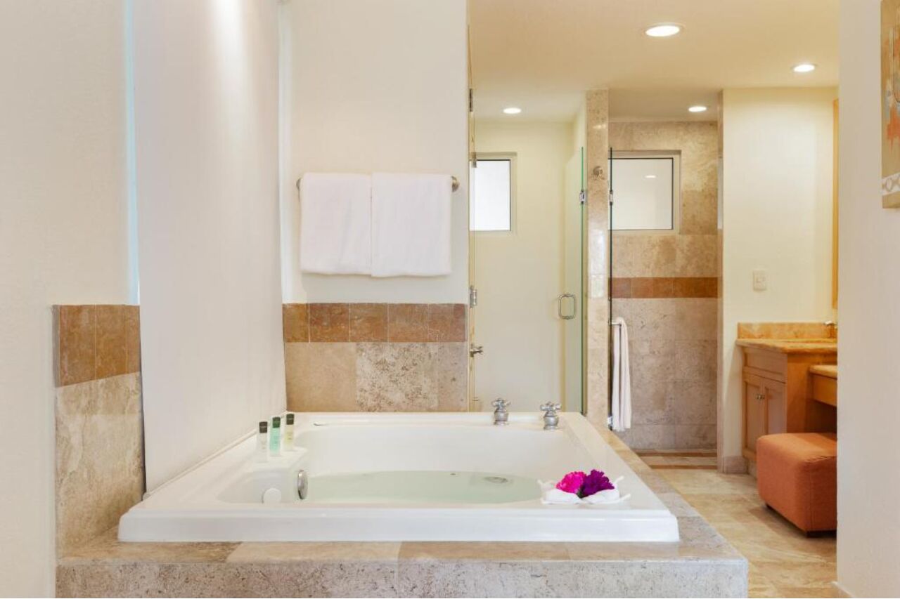 A modern bathroom with a large bathtub, a glass shower enclosure, and a wooden vanity.