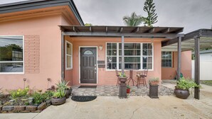 A house with a covered patio, a door, and potted plants. - 4 Mi to Beach: Hollywood Home w/ Patios! (Hollywood)