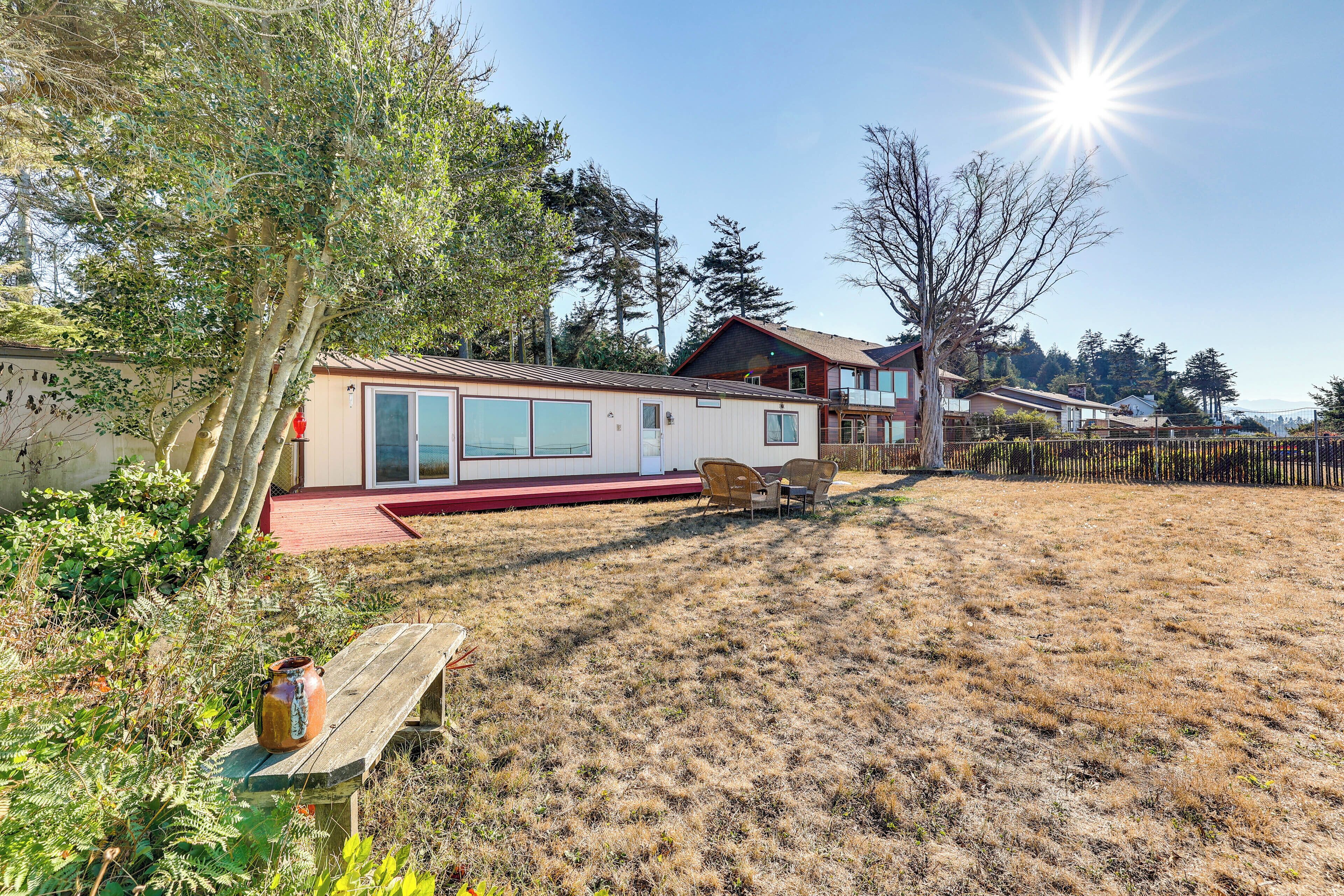 A residential area with a house, a wooden bench, and a fenced yard.