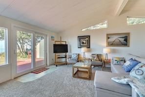 A spacious living room with a large TV, comfortable seating, and artwork on the walls. - Oceanfront Port Angeles Home w/ Yard & Views! (Port Angeles)