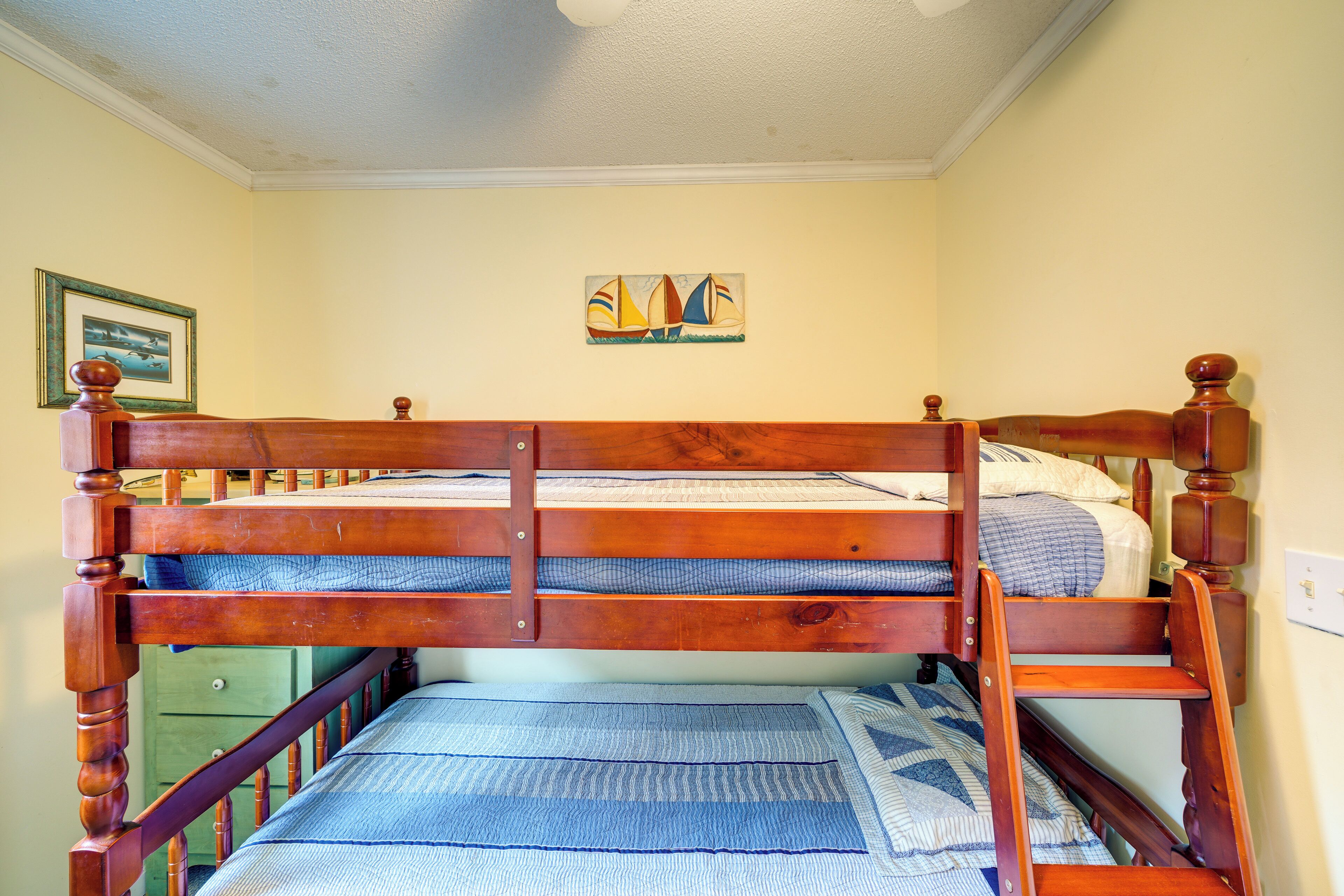 Ein Etagenbett mit Holzrahmen und blauer Bettwäsche.