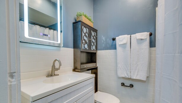 A bathroom with a white sink, a toilet, and a mirror above the sink. - Convenient Dayton Vacation Rental Near Downtown! (Dayton)