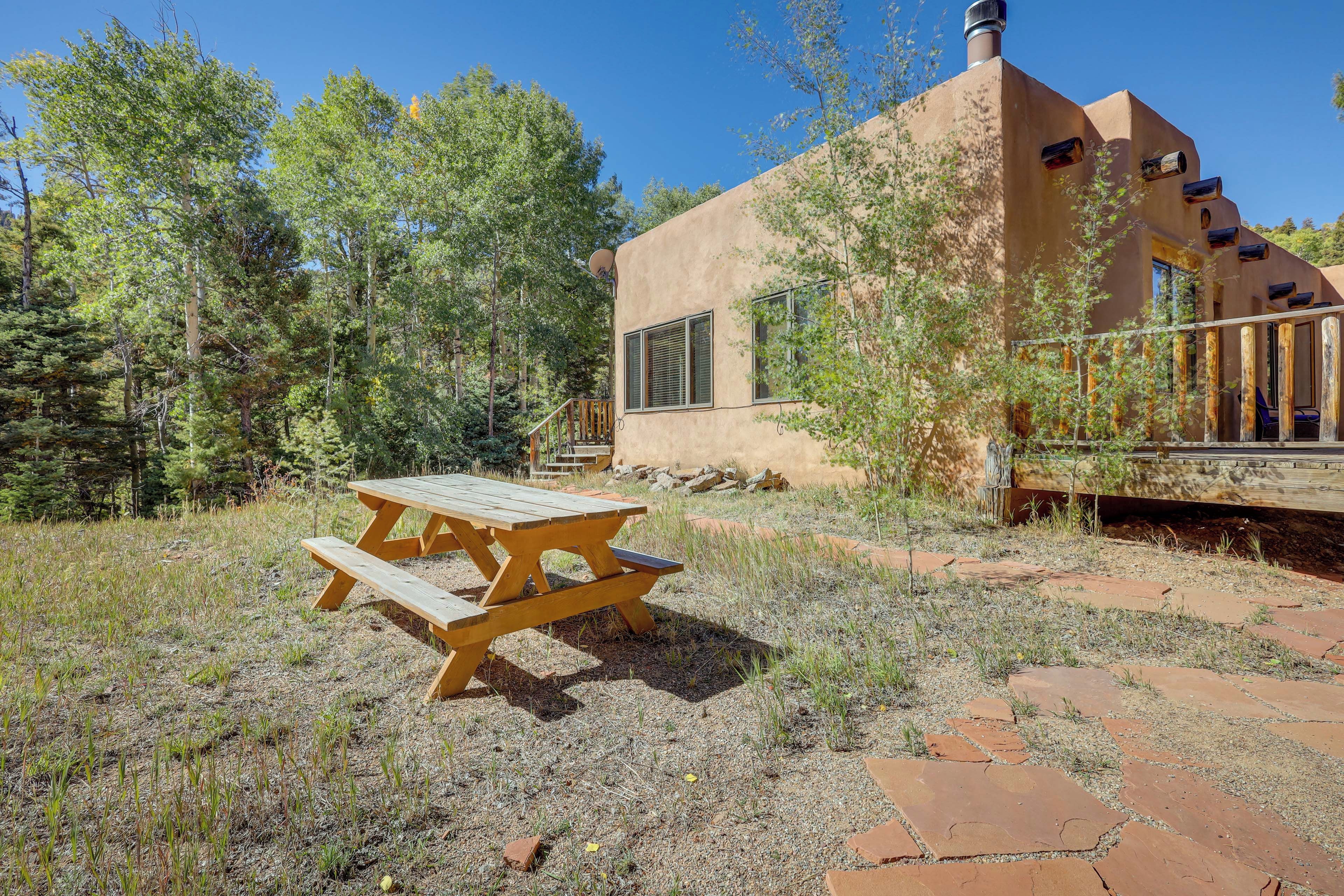 A rustic building with a wooden deck and a picnic table in a natural setting.