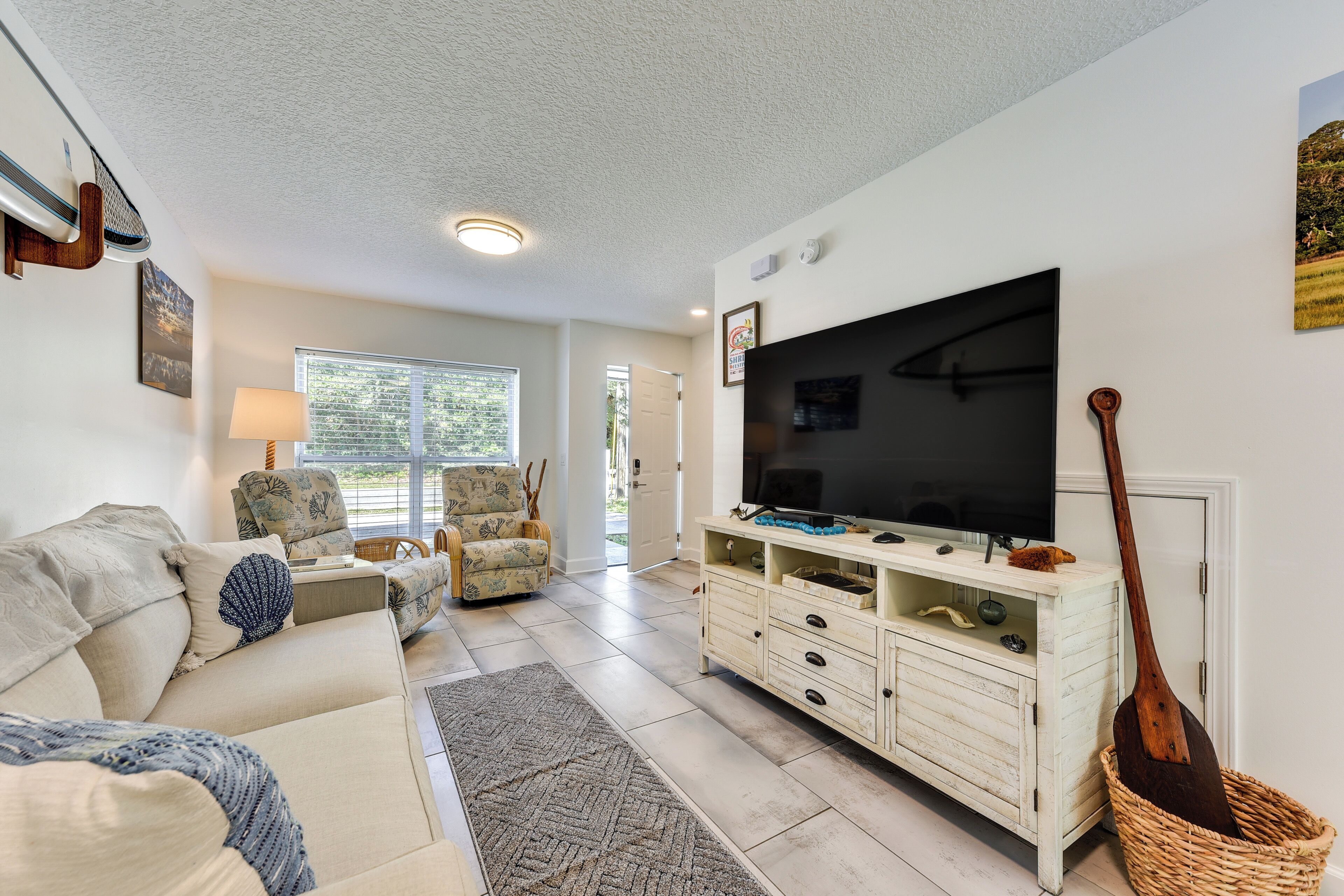 A living room with a sofa, TV, and a wooden spoon in a basket.
