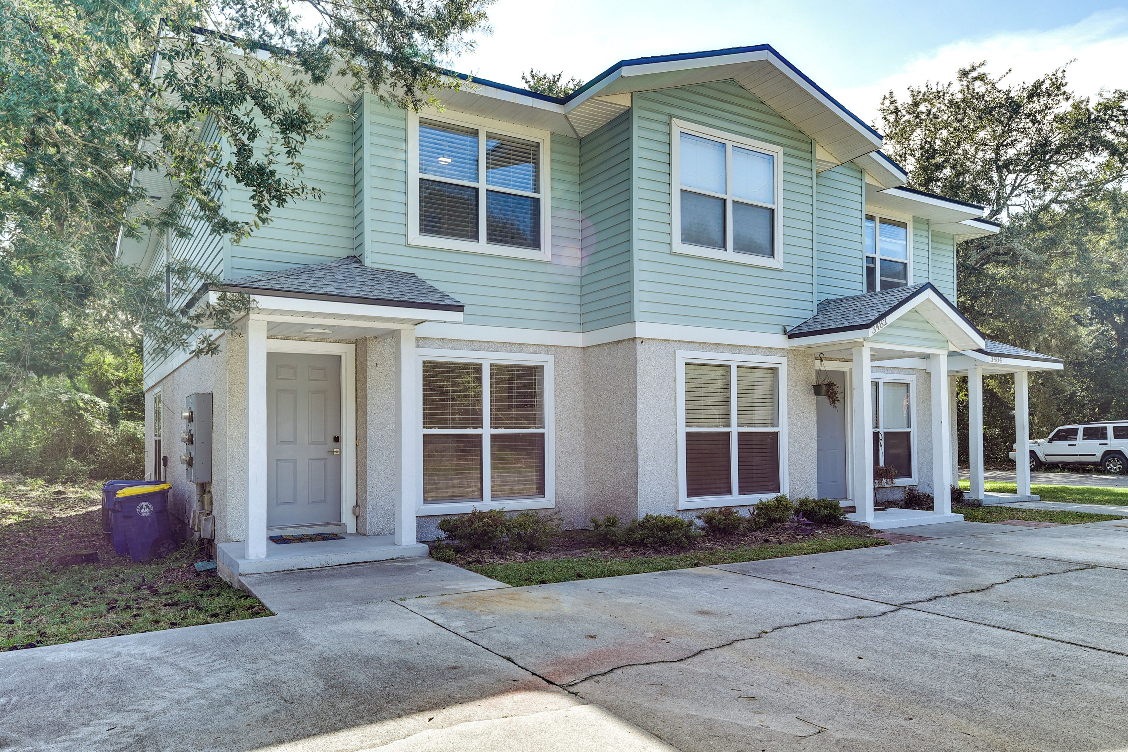 A two-story house with a front porch, a garage, and a driveway.