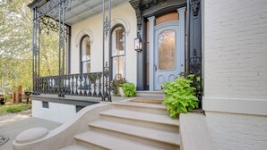 A staircase leading to a porch with a wrought iron railing and a door with glass panels. - Chic & Historic Apartment ~ 6 Mi to Louisville! (New Albany)