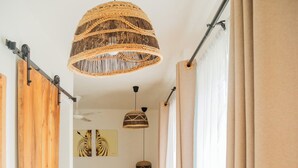 A hallway with a bed, a hanging woven light fixture, and a view of a room with a bed and curtains. - Boho Boutique Hotel - Beachfront , Adults Only , Private Pool (Kiwengwa)