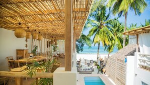 A beachside villa with a pool, dining area, and lounge chairs. - Boho Boutique Hotel - Beachfront , Adults Only , Private Pool (Kiwengwa)
