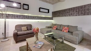 A modern living room with two grey sofas, a glass coffee table, and a floor lamp. - Servi 7 (Florence)