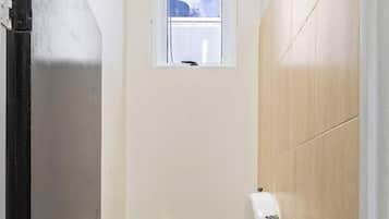 Un baño pequeño con inodoro, lavamanos y ventana.