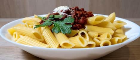 Un plato de pasta con salsa roja y decoración.
