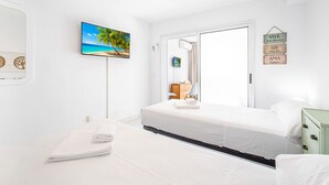A hotel room with a bed, a television, a painting of a beach, and a motivational sign on the wall. - Albatros 13-8 Estudio Levante Beach (Benidorm)