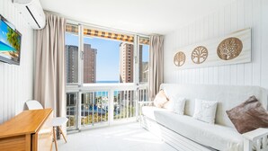 A bright room with a white sofa, a wooden desk, and a TV on the wall. - Albatros 13-8 Estudio Levante Beach (Benidorm)