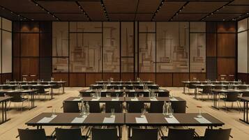 A conference room with multiple tables and chairs, equipped with water bottles and name cards.
