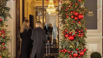 Entrada de hotel con un árbol de Navidad decorado con adornos y luces rojas.