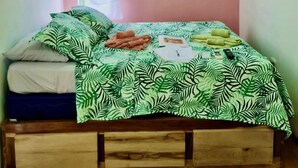 Ein Schlafzimmer mit einem Bett, einem wandmontierten Fernseher, einer Klimaanlage und einem Fenster.