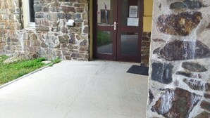 Un edificio de piedra con techo de madera y patio de hormigón.