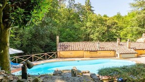 A swimming pool surrounded by lush greenery and a building with a tiled roof. - Molin Barletta, Private Pool, Nature (Marliana)