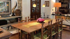 A rustic dining area with a wooden table, chairs, and a stone wall. - Molin Barletta, Private Pool, Nature (Marliana)