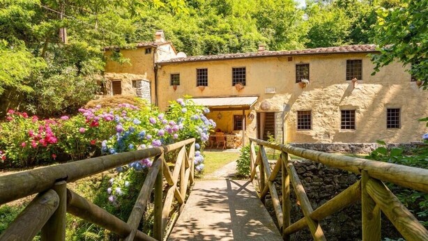 A rustic stone building with a wooden bridge leading to a patio area. - Molin Barletta, Private Pool, Nature (Marliana)
