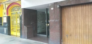 A building entrance with a wooden door and a yellow gate. - Cozy apartment in the Center of Buenos Aires (Buenos Aires)